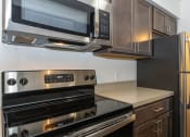 Thumbnail 14 of 18 - a kitchen with a stove microwave and refrigerator
