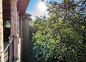 Thumbnail 28 of 48 - Stone column balcony overlooking mature oak trees at Nalle Woods of Westlake Apartments, Texas, 78746