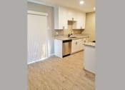 Thumbnail 9 of 33 - Kitchen view with stainless appliances, white cabinets, stone counters, and wood look flooring.