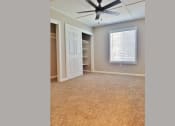 Thumbnail 12 of 33 - Bedroom view with carpet flooring, well lit window, ceiling fan, and closet with built in shelfing