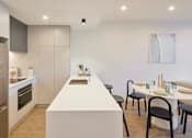 Thumbnail 11 of 33 - a kitchen and dining area with a white counter top