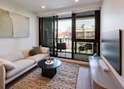 Thumbnail 12 of 33 - a living room with a couch and a coffee table and sliding glass doors
