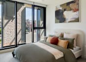 Thumbnail 21 of 33 - a bedroom with a bed and a large window