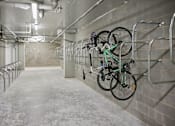 Thumbnail 29 of 33 - a row of bikes hanging on a wall in a parking garage