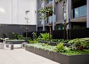 Thumbnail 30 of 33 - a courtyard with benches and plants in front of a building