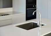 Thumbnail 26 of 33 - a white kitchen with a sink and a faucet