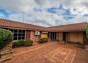 Thumbnail 7 of 12 - A red brick patio with a geometric design in the middle.