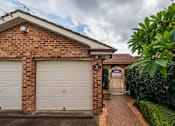 Thumbnail 3 of 12 - A brick house with a white garage door and a sign that says 151.