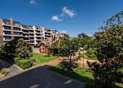 Thumbnail 14 of 17 - A residential area with apartment buildings and greenery.
