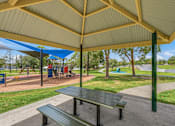 Thumbnail 14 of 20 - A park with a picnic table and playground equipment.
