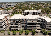 Thumbnail 11 of 17 - A large apartment complex with multiple buildings and balconies.
