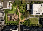 Thumbnail 15 of 17 - A large building complex with a green space in the middle.