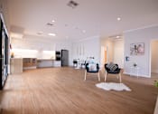 Thumbnail 1 of 9 - A modern living room with a white rug and a black chair.