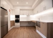 Thumbnail 6 of 9 - A modern kitchen with wooden floors and stainless steel appliances.