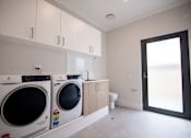 Thumbnail 9 of 9 - A laundry room with a washer and dryer.