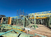 Thumbnail 9 of 9 - A construction site with a large metal framework and wooden beams.