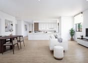 Thumbnail 1 of 2 - A modern living room with a dining table and a kitchen in the background.