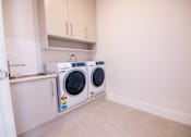 Thumbnail 12 of 12 - A laundry room with a washer and dryer.