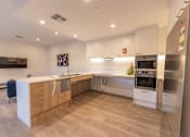 Thumbnail 8 of 11 - A modern kitchen with wooden cabinets and stainless steel appliances.