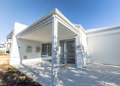 Thumbnail 1 of 11 - A white building with a triangular roof and a glass door.
