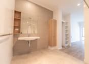Thumbnail 4 of 11 - A bathroom with a sink, mirror, and wooden cabinet.