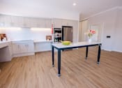 Thumbnail 5 of 15 - A kitchen with a table and chairs in the middle of the room.