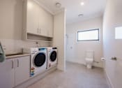 Thumbnail 8 of 15 - A laundry room with a washer and dryer.