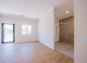 Thumbnail 3 of 15 - A room with wooden floors and white walls.