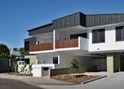 Thumbnail 5 of 6 - A modern house with a white and black exterior and a balcony on the second floor.