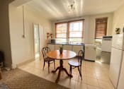 Thumbnail 9 of 12 - a kitchen with a table and a refrigerator and a sink