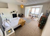 Thumbnail 10 of 12 - a bedroom with a bed and a living room with a desk and a window
