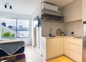 Thumbnail 2 of 9 - a small kitchen with white cabinets and a window