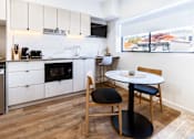 Thumbnail 6 of 20 - a kitchen and dining area with a small table and chairs