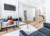 Thumbnail 1 of 20 - a living room with a desk and a tv