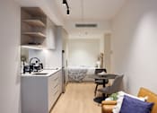 Thumbnail 3 of 11 - a small apartment with a kitchen and a bed