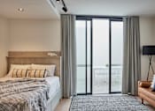 Thumbnail 5 of 11 - a bedroom with a bed and sliding glass doors