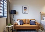 Thumbnail 4 of 11 - a couch with pillows in a room with a bed