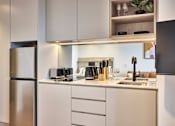 Thumbnail 8 of 11 - a kitchen with white cabinets and a stainless steel refrigerator and sink