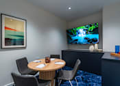 Thumbnail 32 of 34 - a conference room with a table and a tv on the wall