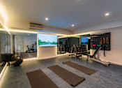 Thumbnail 30 of 34 - a gym with yoga mats and a tv on the wall