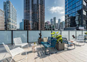 Thumbnail 21 of 34 - a roof deck with chairs and a view of the city