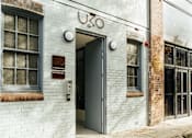 Thumbnail 1 of 11 - the front of a white brick building with an open door