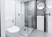 Thumbnail 18 of 20 - a white bathroom with a shower and a toilet