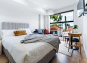 Thumbnail 13 of 20 - a bedroom with a bed and a large window