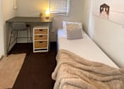 Thumbnail 8 of 12 - a small bedroom with a bed and a desk