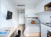 Thumbnail 5 of 14 - a bedroom with a bed and a desk and a television