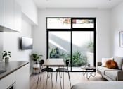 Thumbnail 2 of 14 - a living room with a couch and a table and a large window