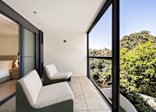 Thumbnail 11 of 24 - A bedroom with a view of the trees outside the window.