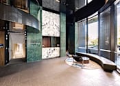 Thumbnail 5 of 24 - A modern interior with a green marble wall and a wooden door.