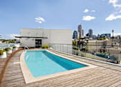 Thumbnail 9 of 24 - A modern building with a pool on the roof.
